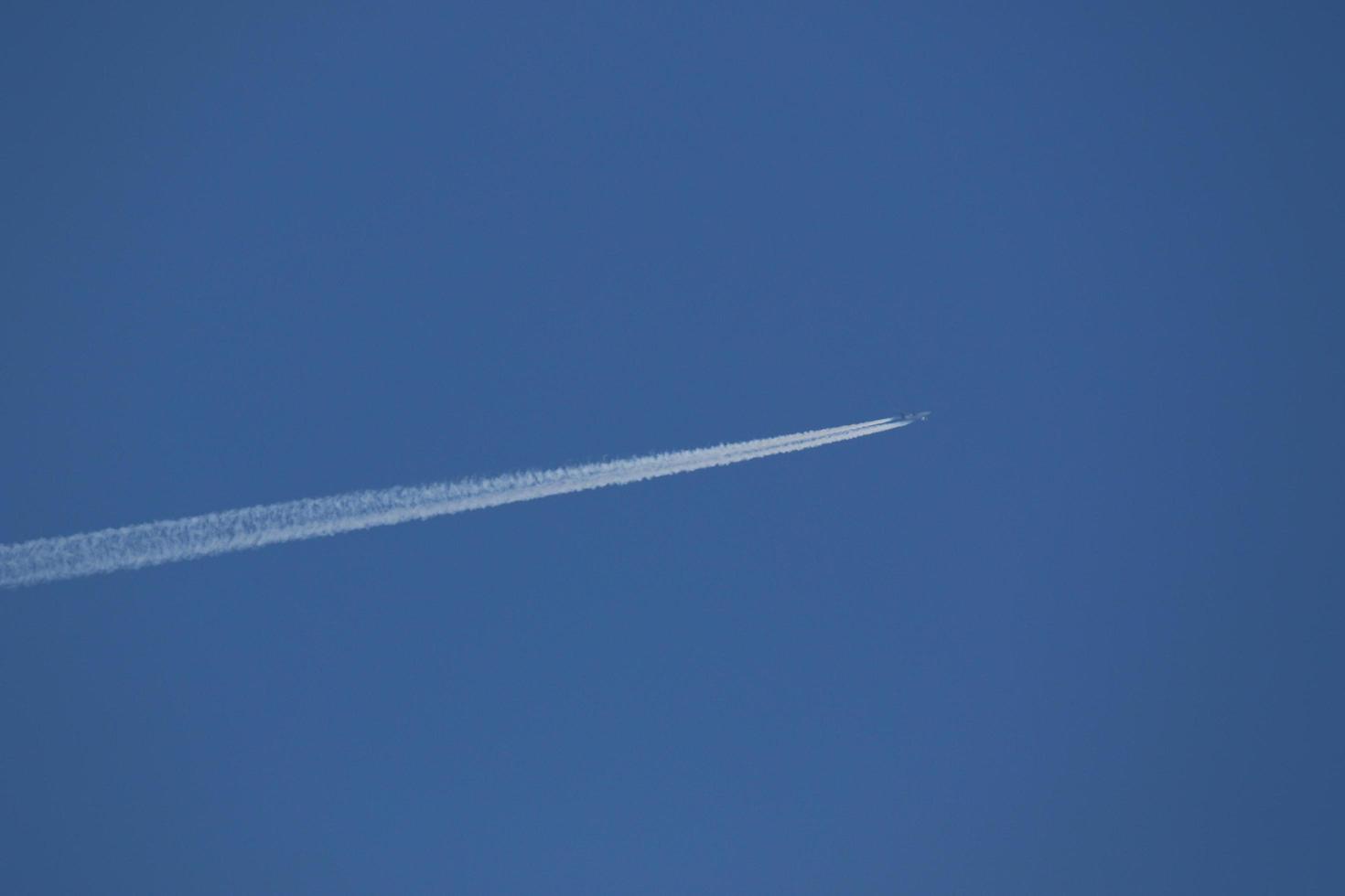 een vlak en damp trails in de lucht foto