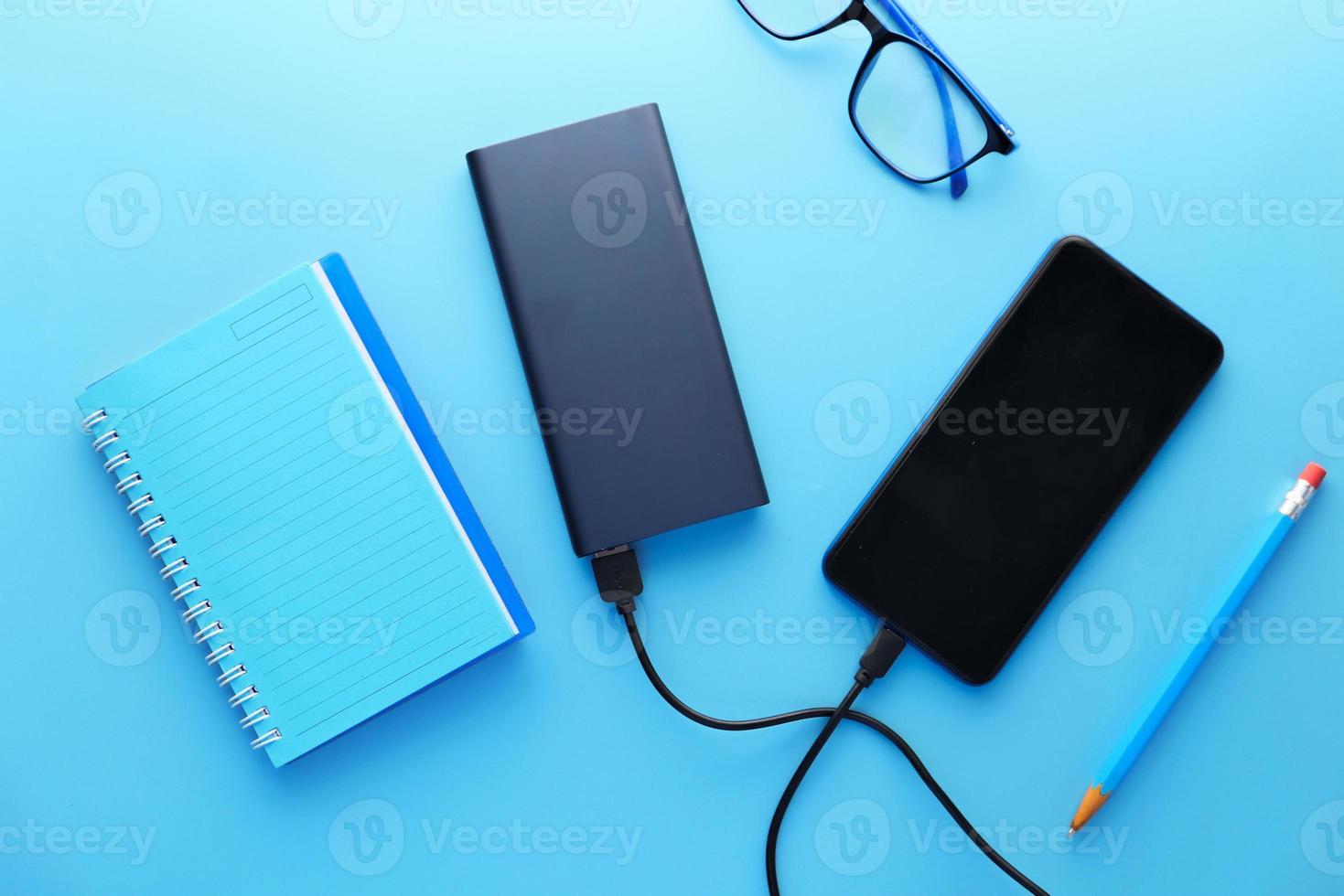 slimme telefoon charing met powerbank op blauwe achtergrond foto