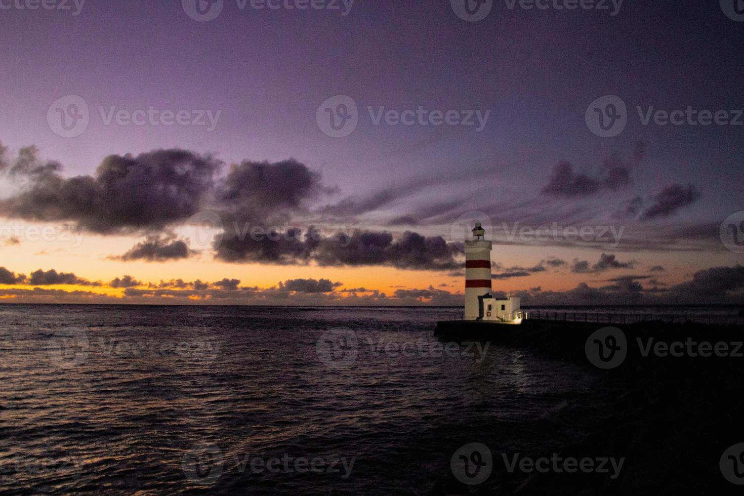 zonsondergang Bij de bewaker oud vuurtoren in IJsland foto