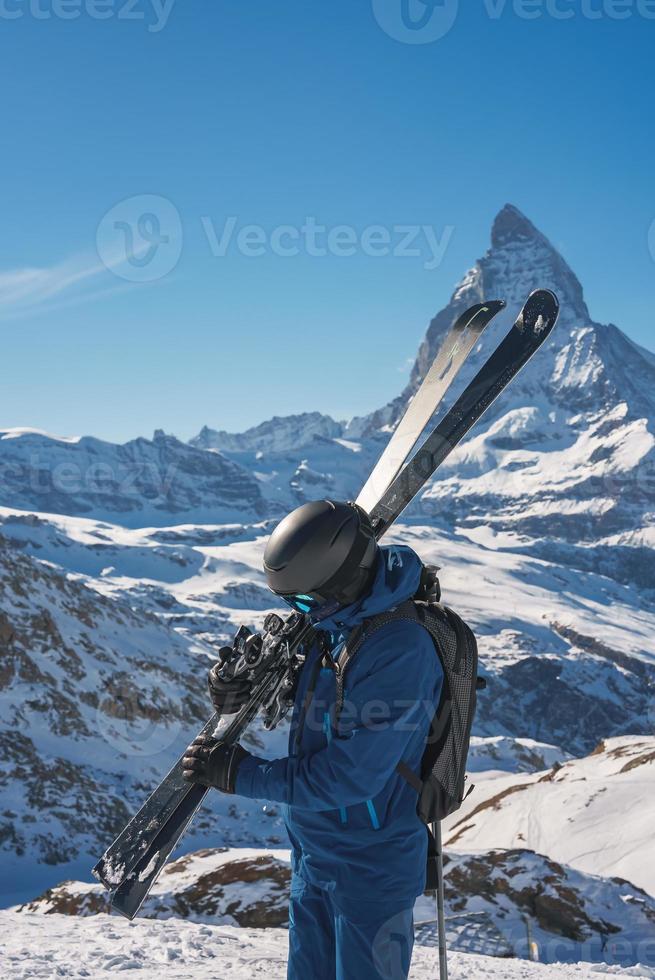 jong skiër genieten van zermatt ski toevlucht. mooi zonnig dag met een skiër omhoog in de bergen. sport- model. foto