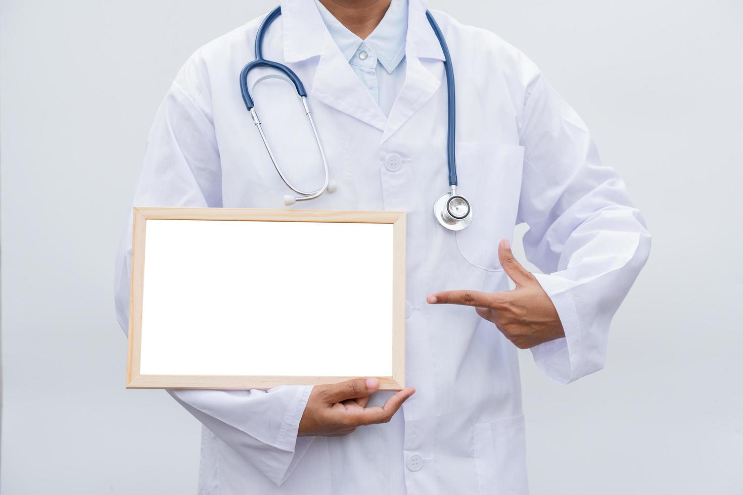 professioneel vrouw dokter in wit jas over- wit geïsoleerd achtergrond en richten naar wit blanco bord. concept van gezondheidszorg, wetenschap en geneeskunde concept foto