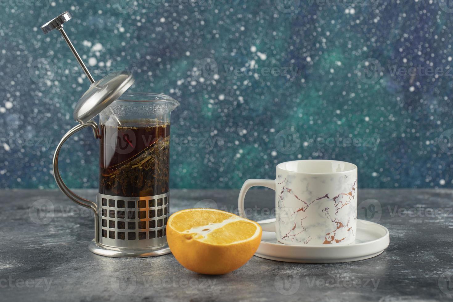 een wit keramiek kopje drank met een theepot op een marmeren achtergrond foto
