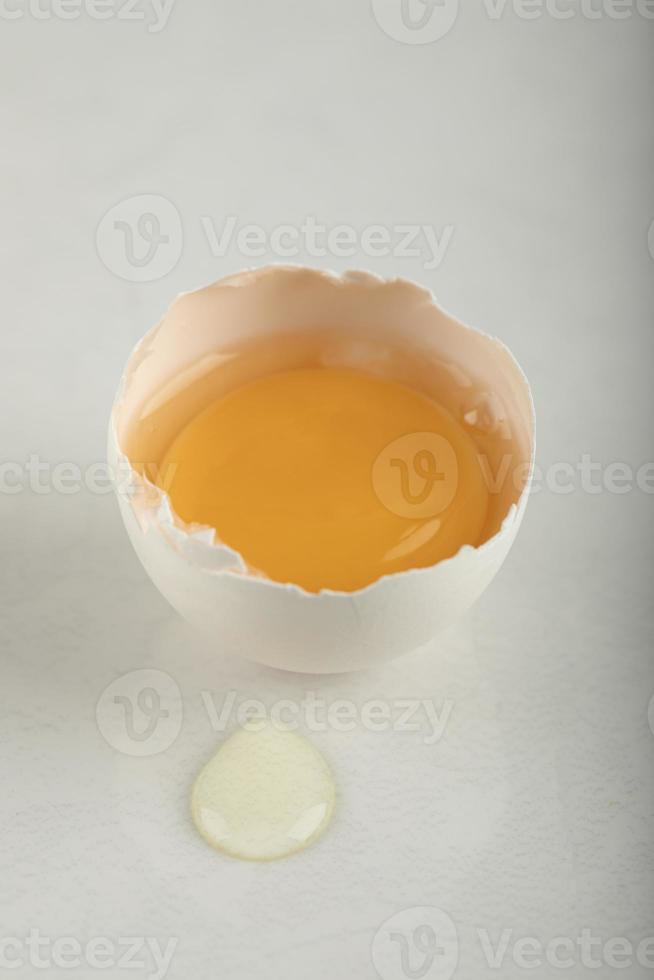 rauw gebroken ei op een witte achtergrond foto