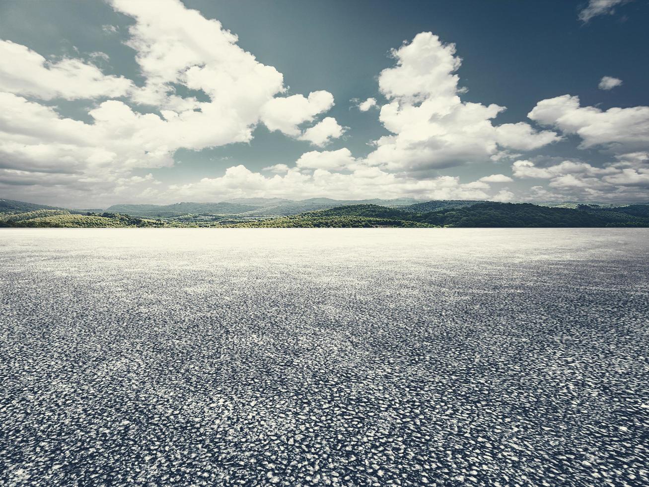 leeg asfalt bestrating met blauw lucht en wit wolk berg achtergrond foto