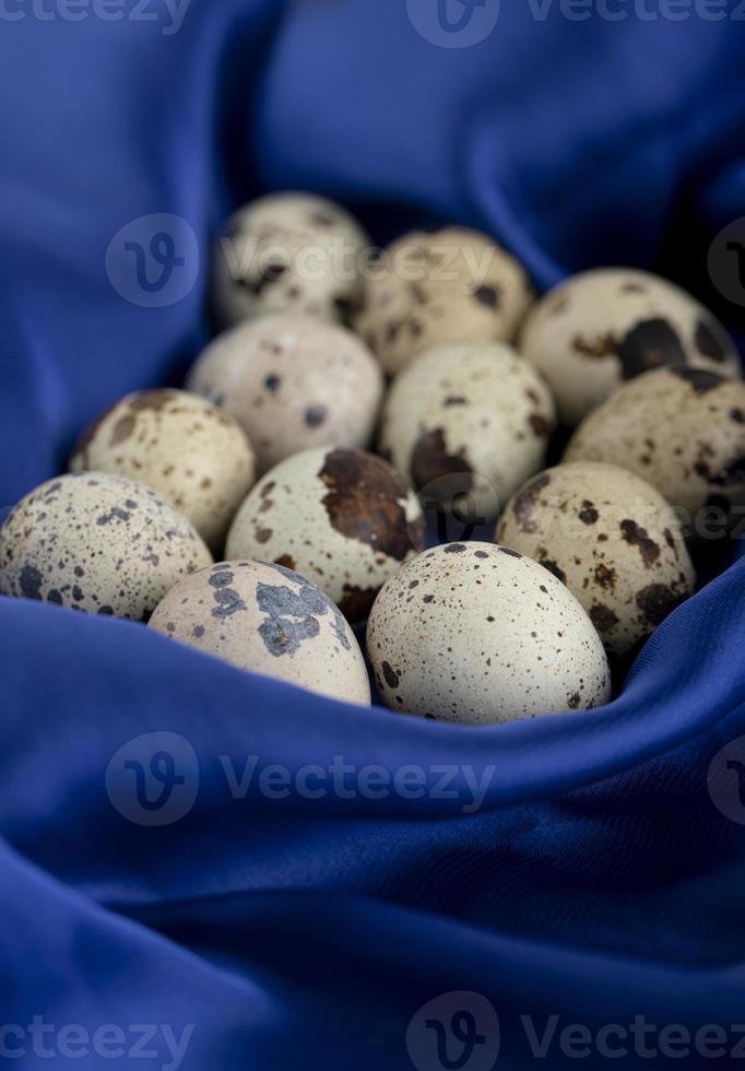 verse boerderij kwarteleitjes op een blauwe satijnen doek foto