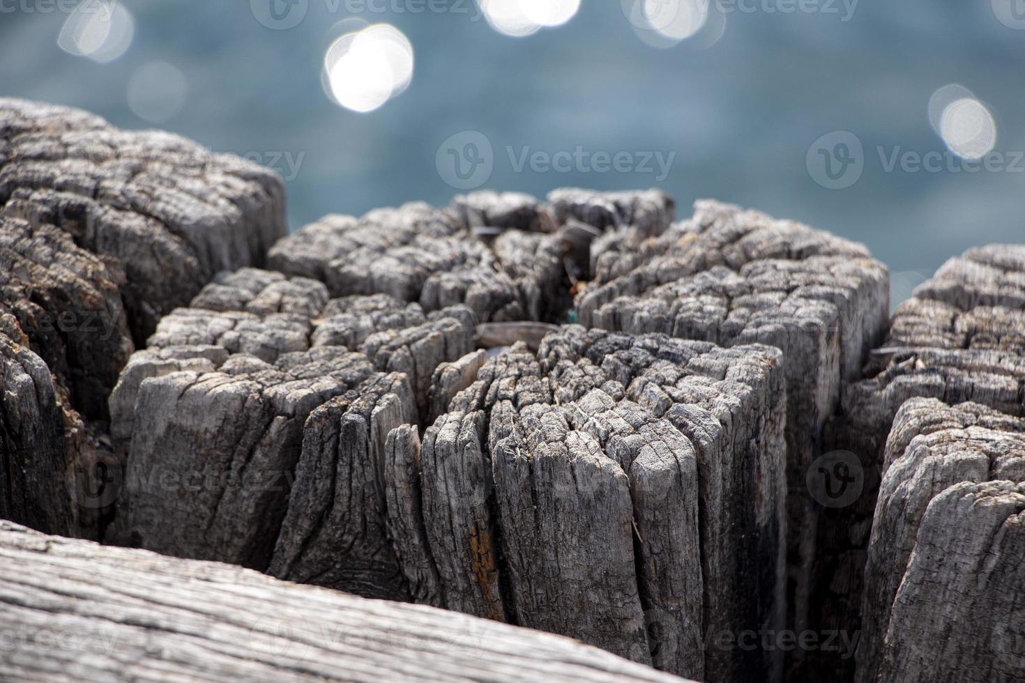 houten structuur van oud hout Aan de strand. houten structuur van de oppervlakte van de pier. houten pier Aan de achtergrond van de zee.close-up van oud verweerd hout foto