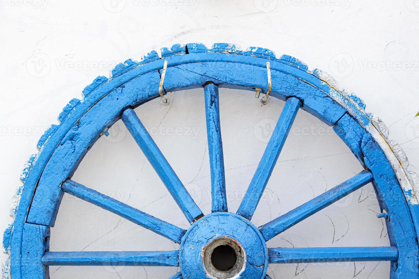 de oud houten wiel Aan een wit muur. detailopname Bekijk de oud houten wiel Aan de achtergrond van de muur van de huis foto