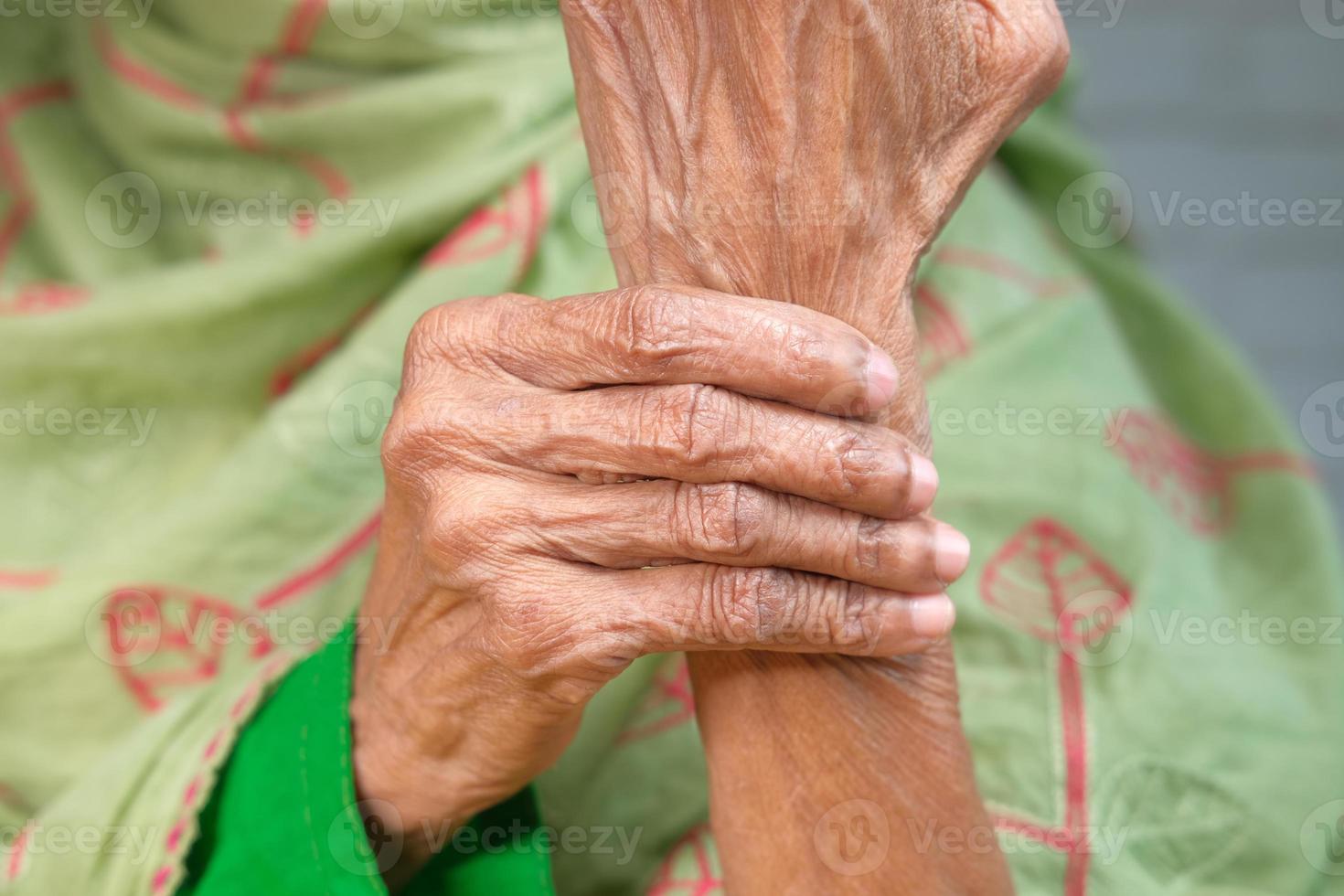 oudere Aziatische vrouw die lijdt aan pijn in de pols foto