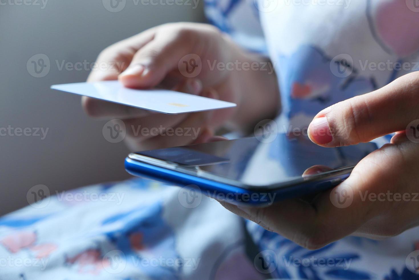 vrouw hand met een creditcard en slimme telefoon foto