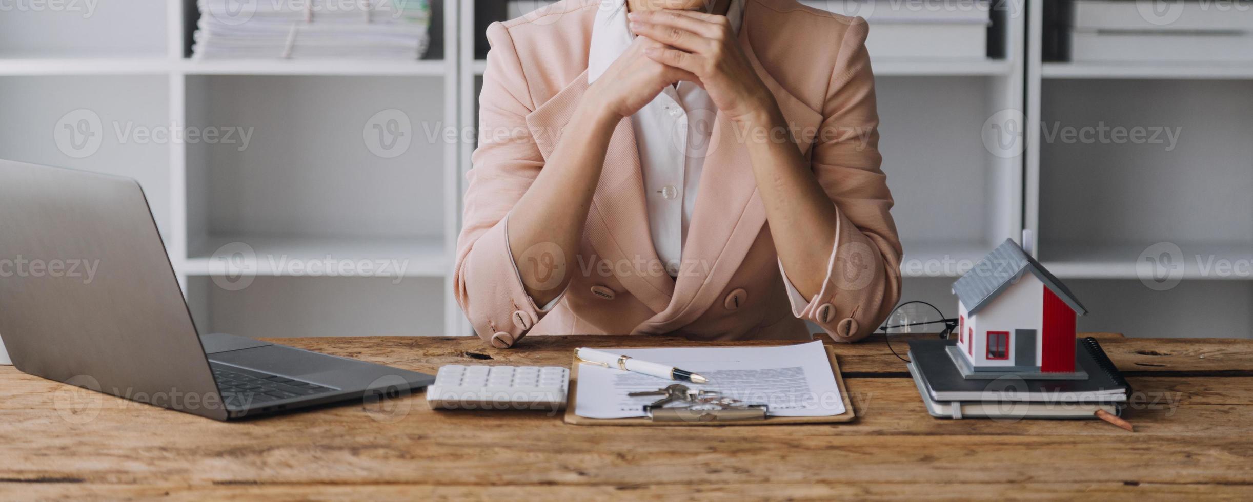 makelaar in onroerend goed presenteren en overleggen met klant bij besluitvorming ondertekenen verzekeringsformulier overeenkomst, kopen en verkopen huismodel, met betrekking tot hypothecaire lening en woningverzekering foto