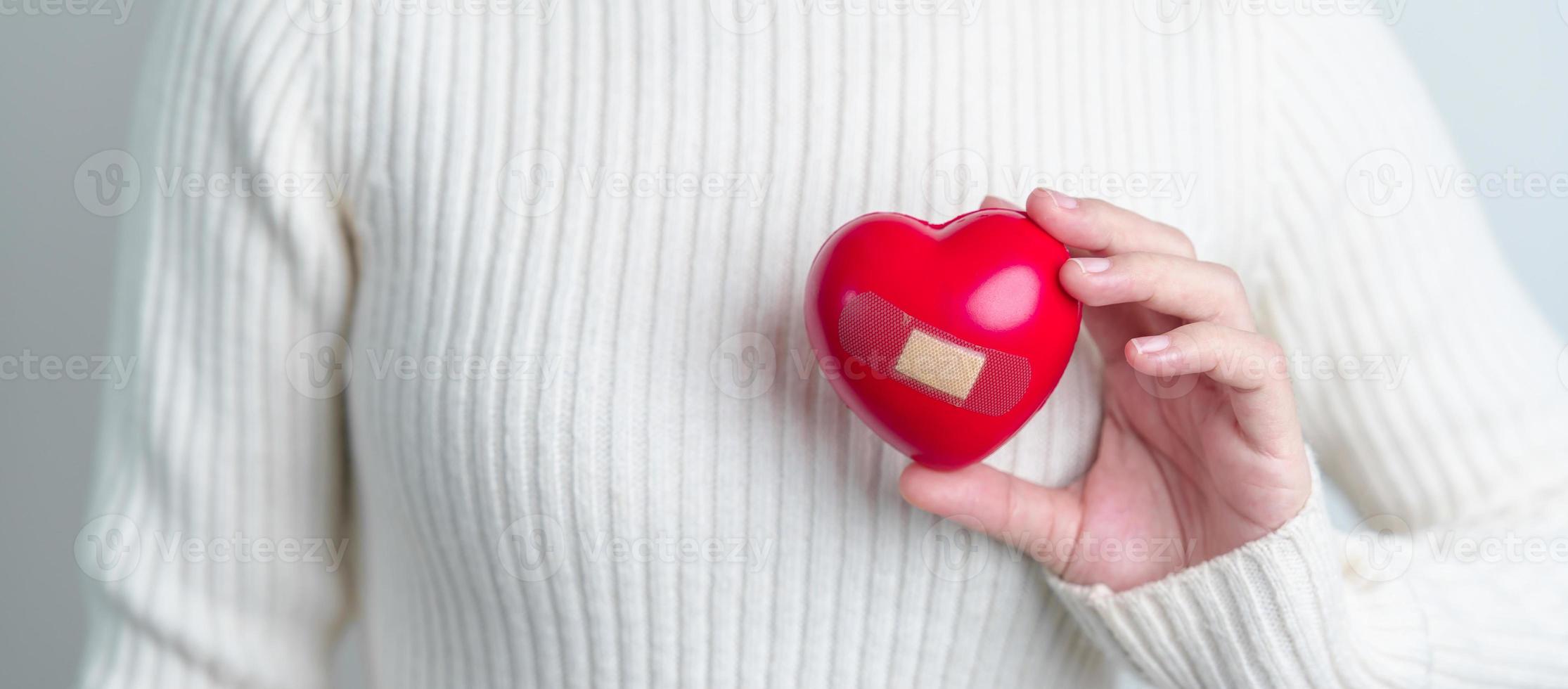 vrouw hand- Holding rood hart vorm geven aan. liefde, schenker, wereld hart dag, wereld Gezondheid dag en verzekering concepten foto