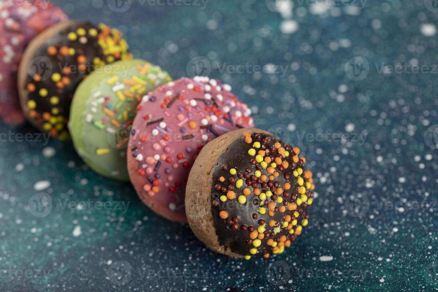kleurrijke kleine donuts met hagelslag op een blauwe achtergrond foto