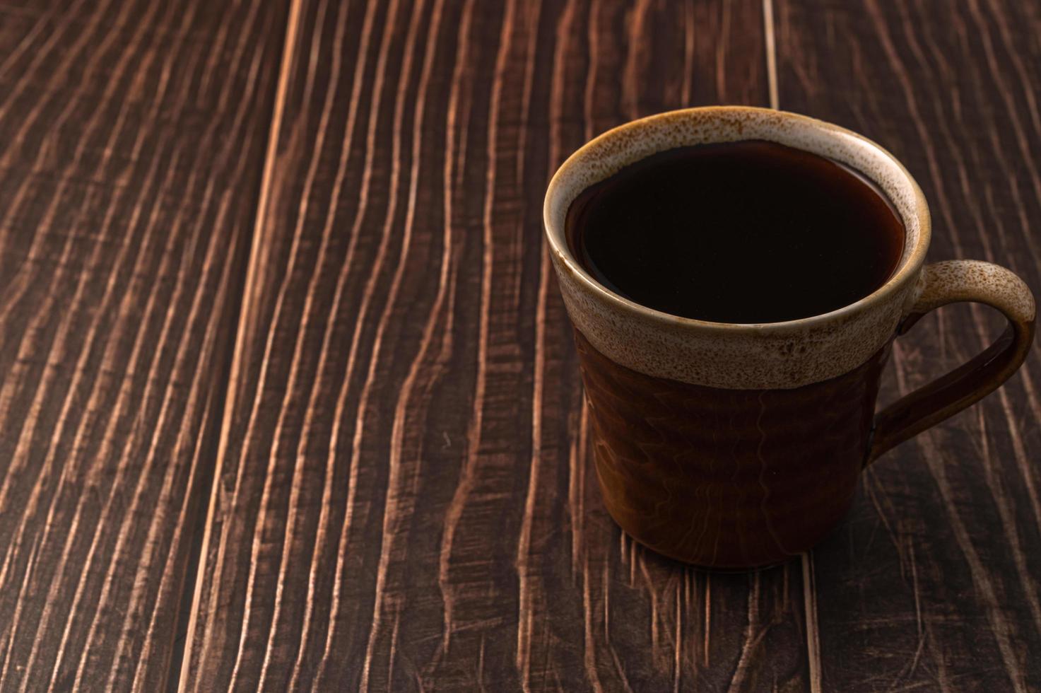 een koffiekopje op een houten tafel foto