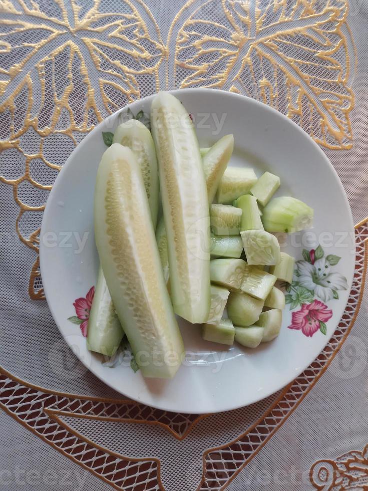 vers plak komkommer in een bord Bij tafel foto