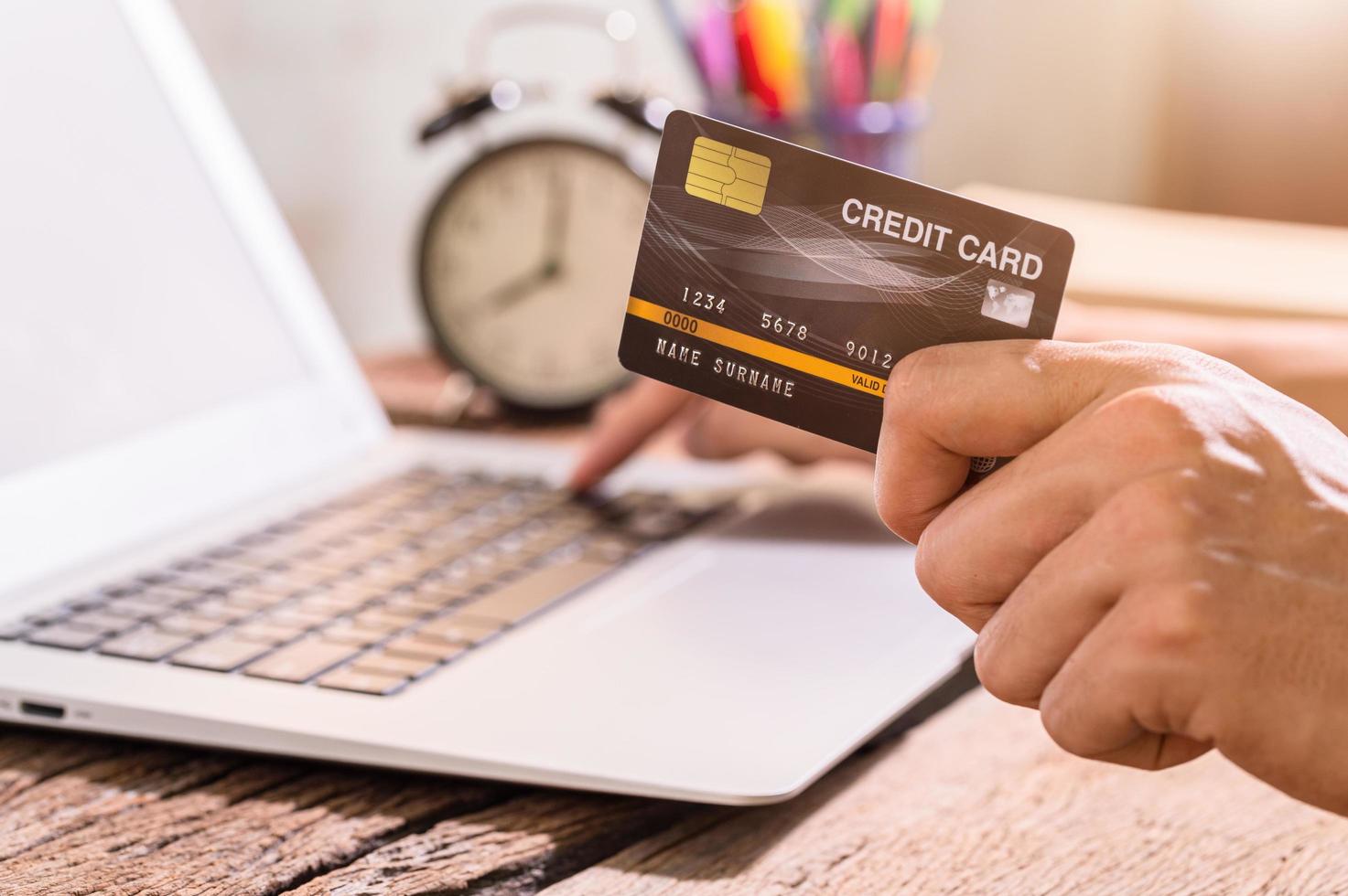 een persoon met een creditcard om online te winkelen via een notebookcomputer foto