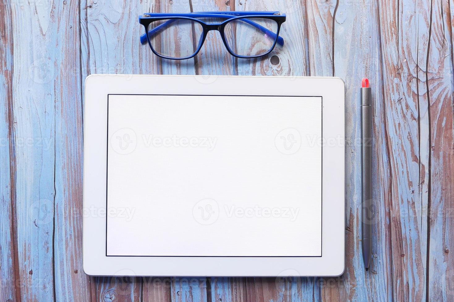 bovenaanzicht van digitale tablet met kantoorbenodigdheden op tafel foto