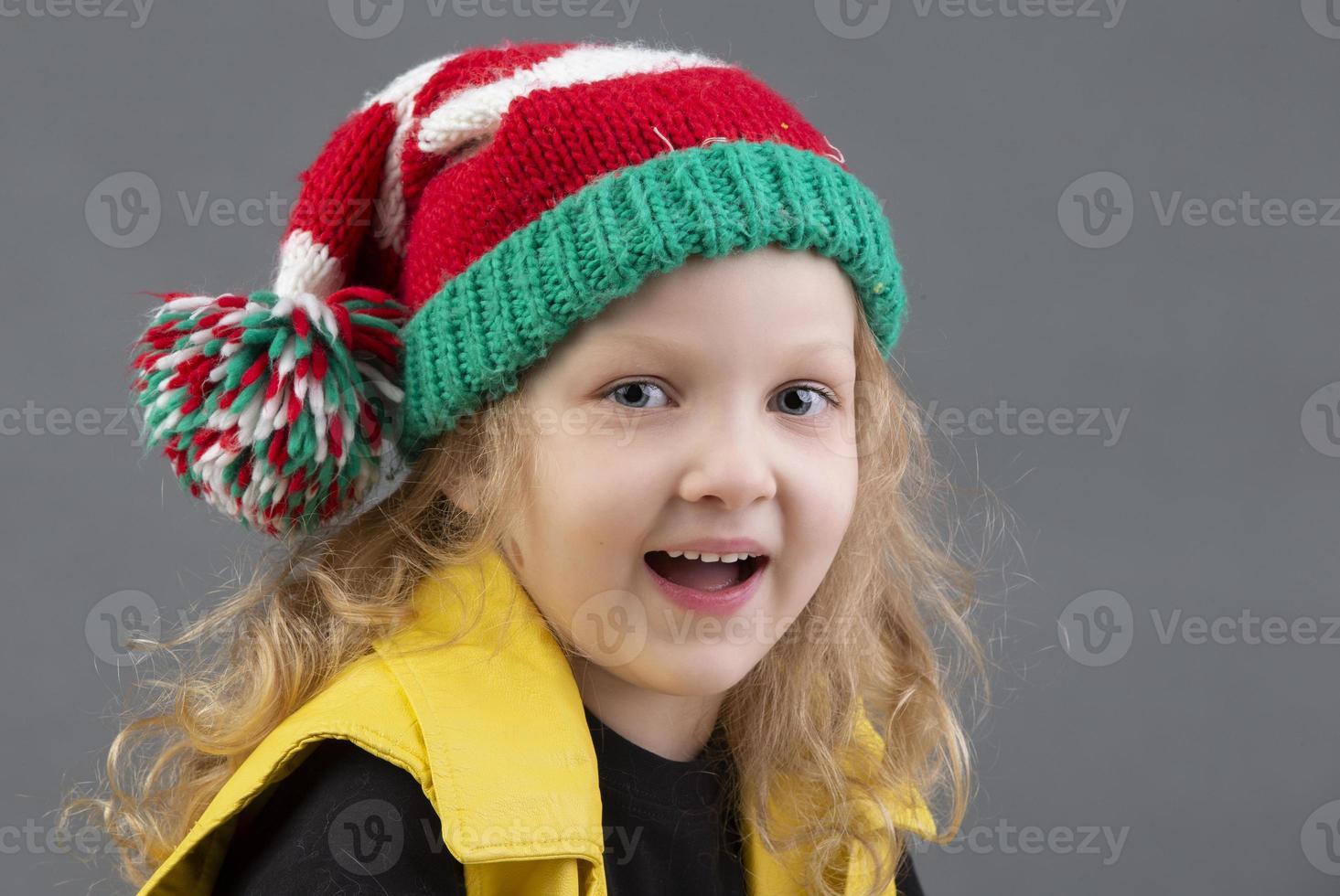 grappig weinig meisje in een Kerstmis hoed. portret van een vrolijk en gelukkig kind. foto