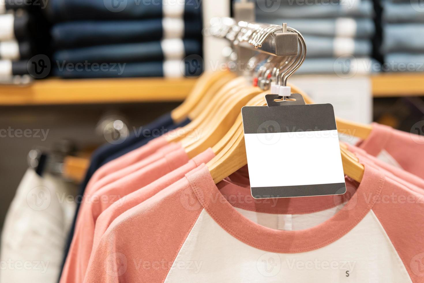 blanco label met kleren hangen Aan een plank in een ontwerper kleren op te slaan. kleding hangende Aan een kleding rek in een op te slaan foto