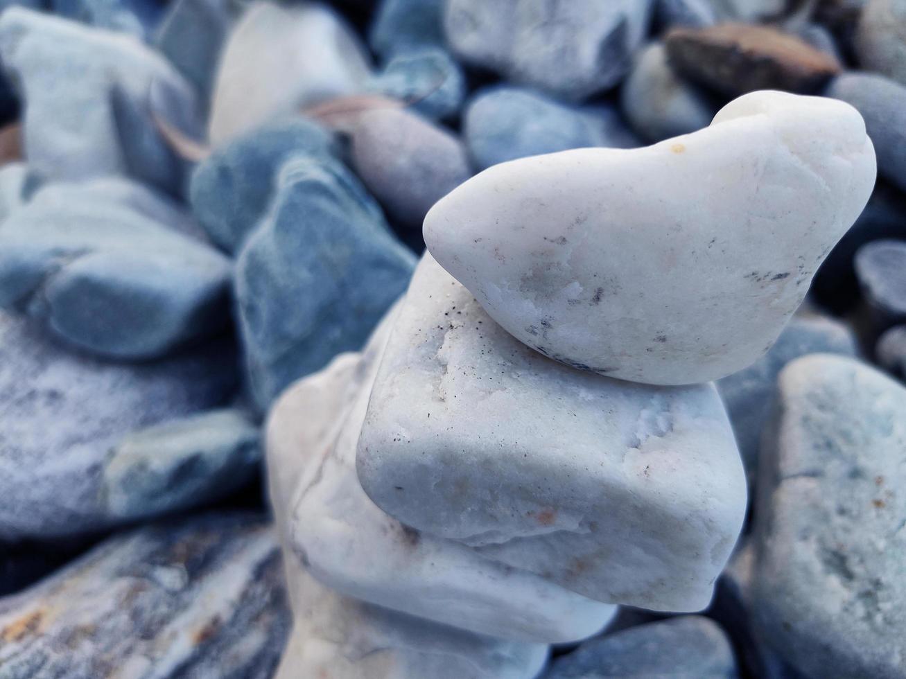 stack van driehoekig stenen.groep van wit en kleurrijk stenen.kiezel toren Aan de stenen kust.stenen piramide Aan kiezelsteen strand symboliseert stabiliteit,zen,rock,harmonie,balans.ondiep diepte van veld. foto