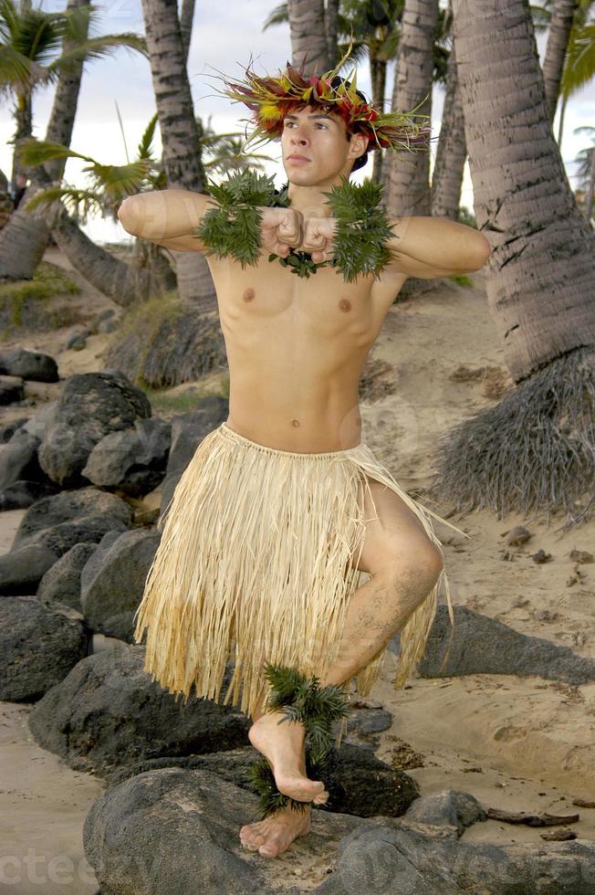 mannetje hula danser poses in voorkant van palm bomen Aan de strand foto