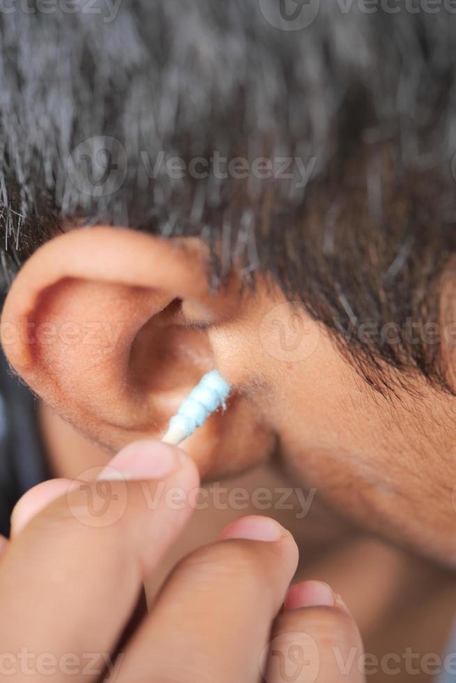 mannen gebruik makend van oor katoen bar foto