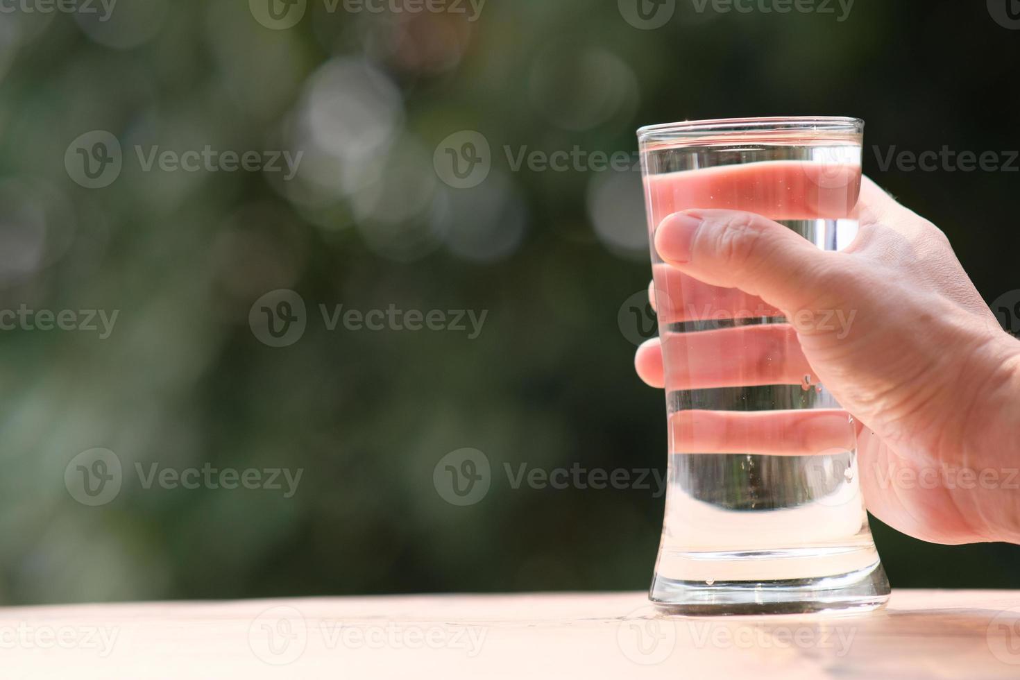 mineraal drinkwater op houten tafel en water in glas foto