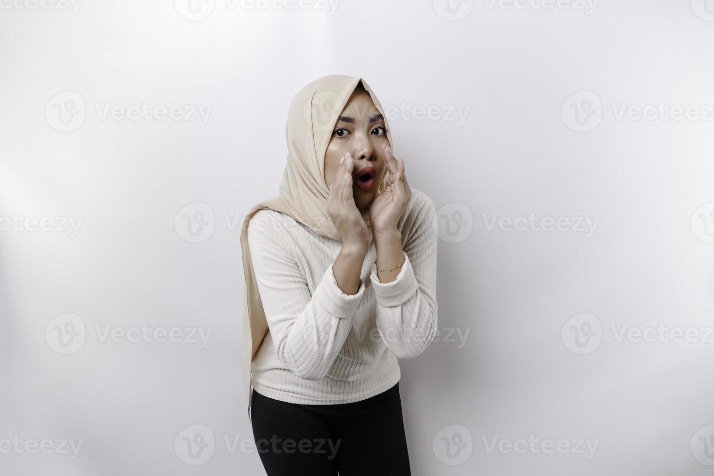 jong mooi Aziatisch moslim vrouw vervelend een hoofddoek geschreeuw en schreeuwen luid met een hand- Aan haar mond. communicatie concept. foto