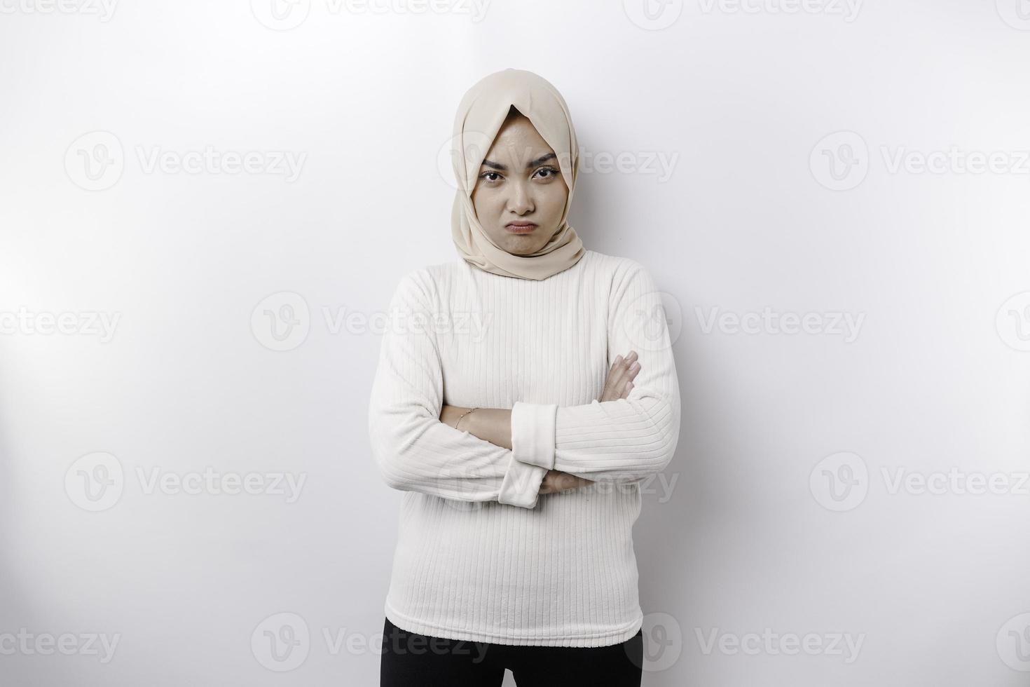 een portret van een Aziatisch moslim vrouw vervelend een hoofddoek geïsoleerd door wit achtergrond looks depressief foto