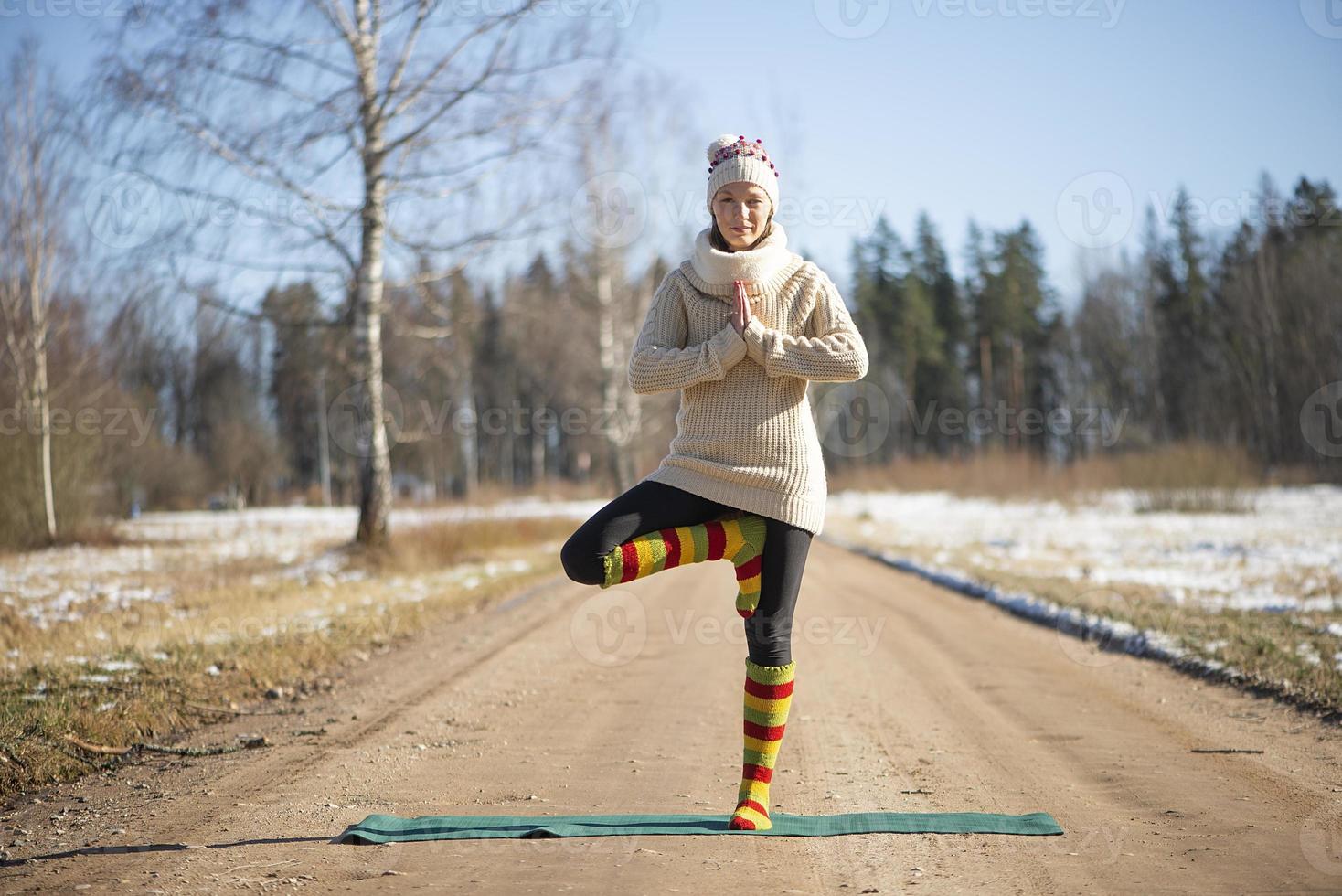 een jonge atletische vrouw voert buiten yoga- en meditatieoefeningen uit foto