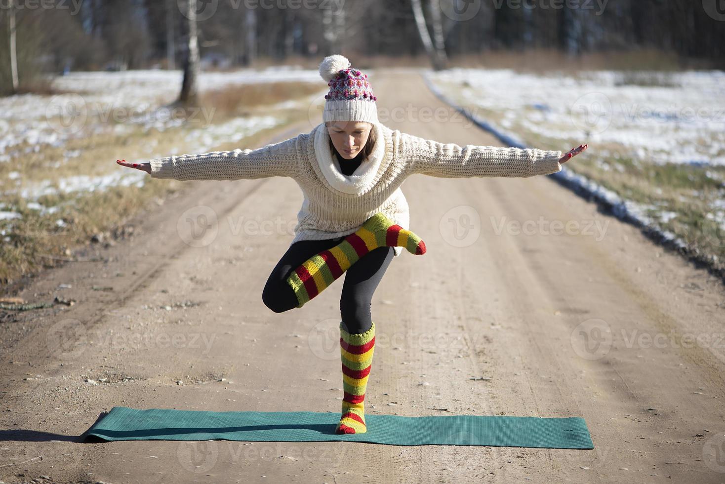 een jonge atletische vrouw voert buiten yoga- en meditatieoefeningen uit foto