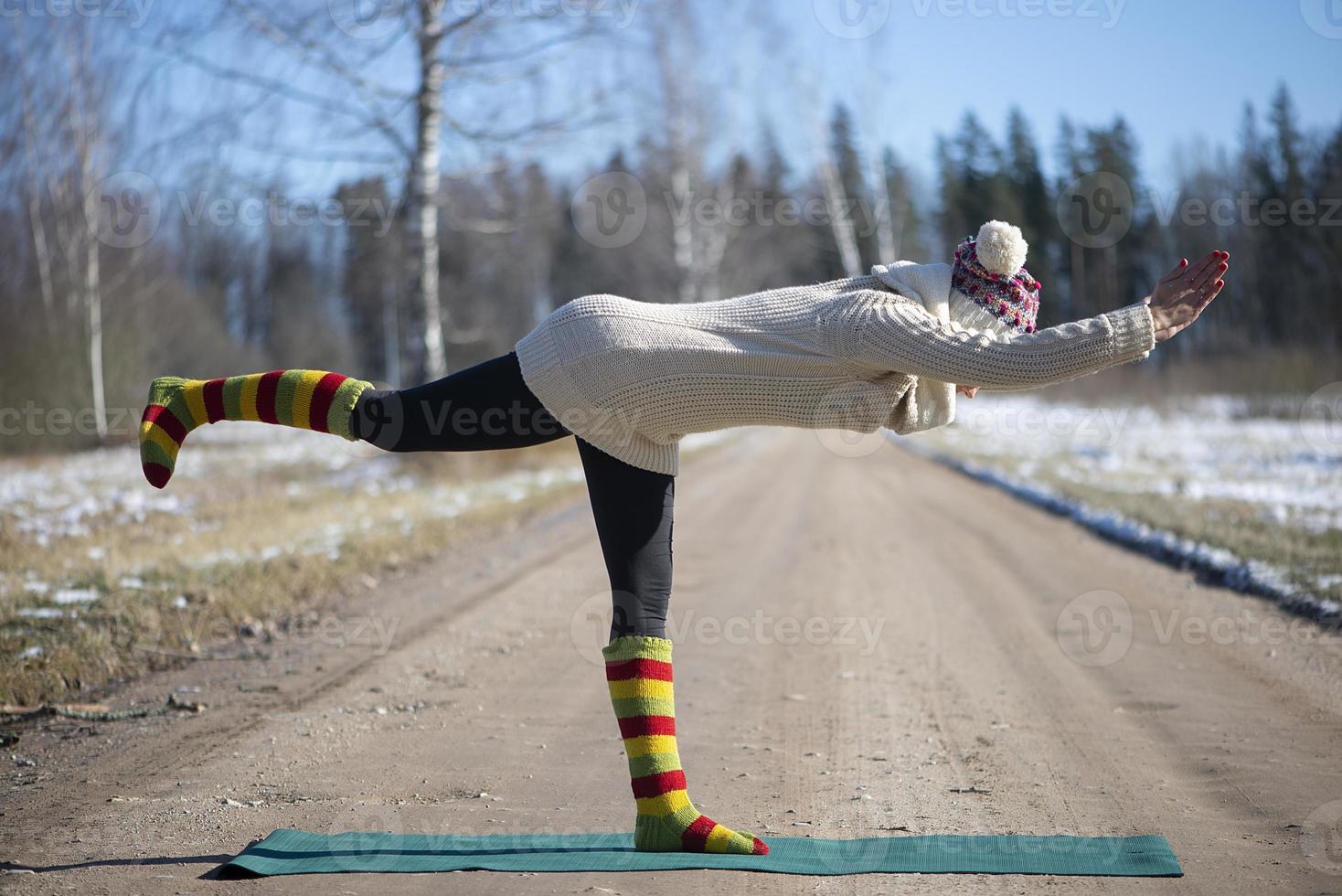 een jonge atletische vrouw voert buiten yoga- en meditatieoefeningen uit foto