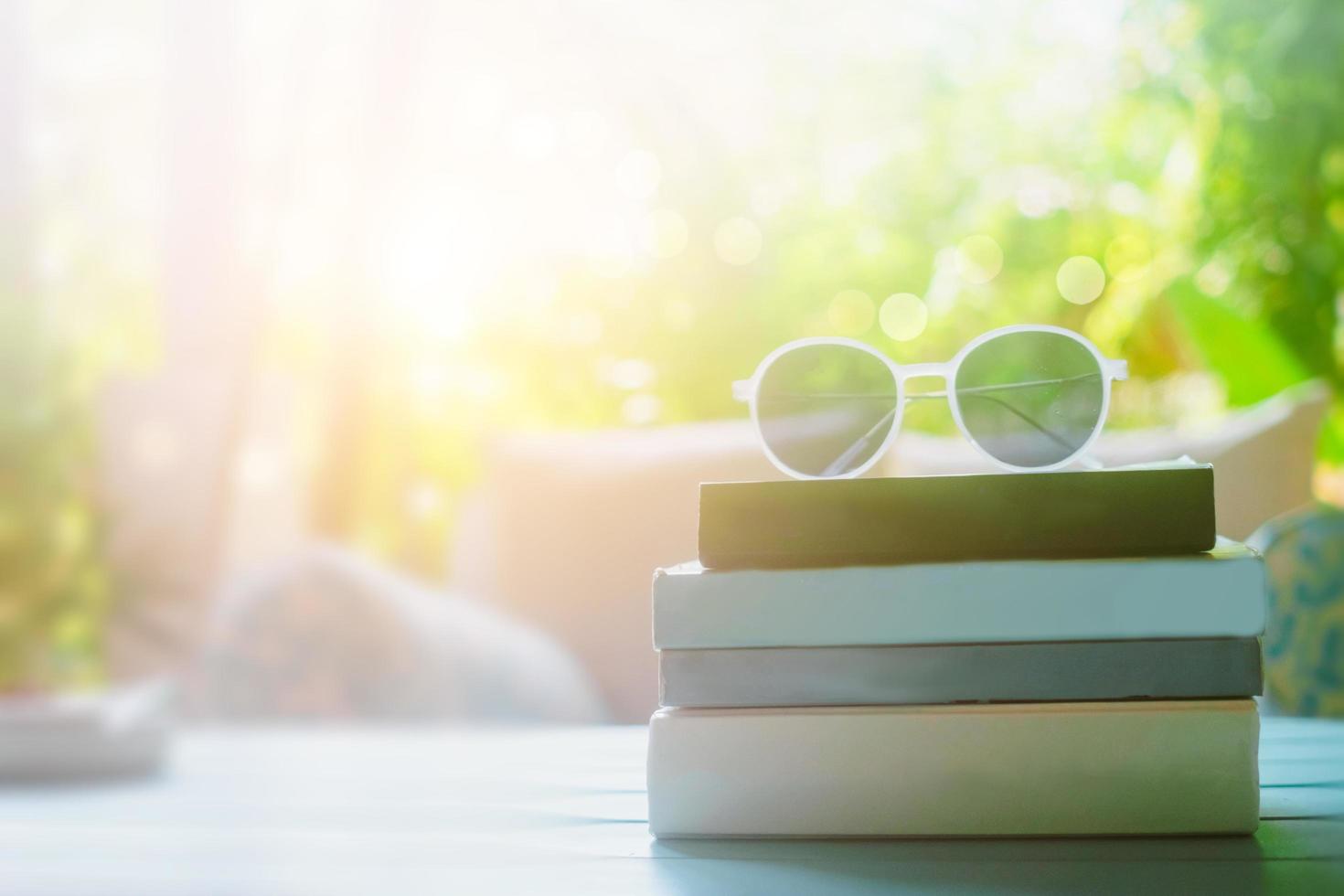 boeken op een tafel met zonnebril bovenop in een resortkamer op vakantie, lezen en ontspannen therapie-onderwijsconcept foto