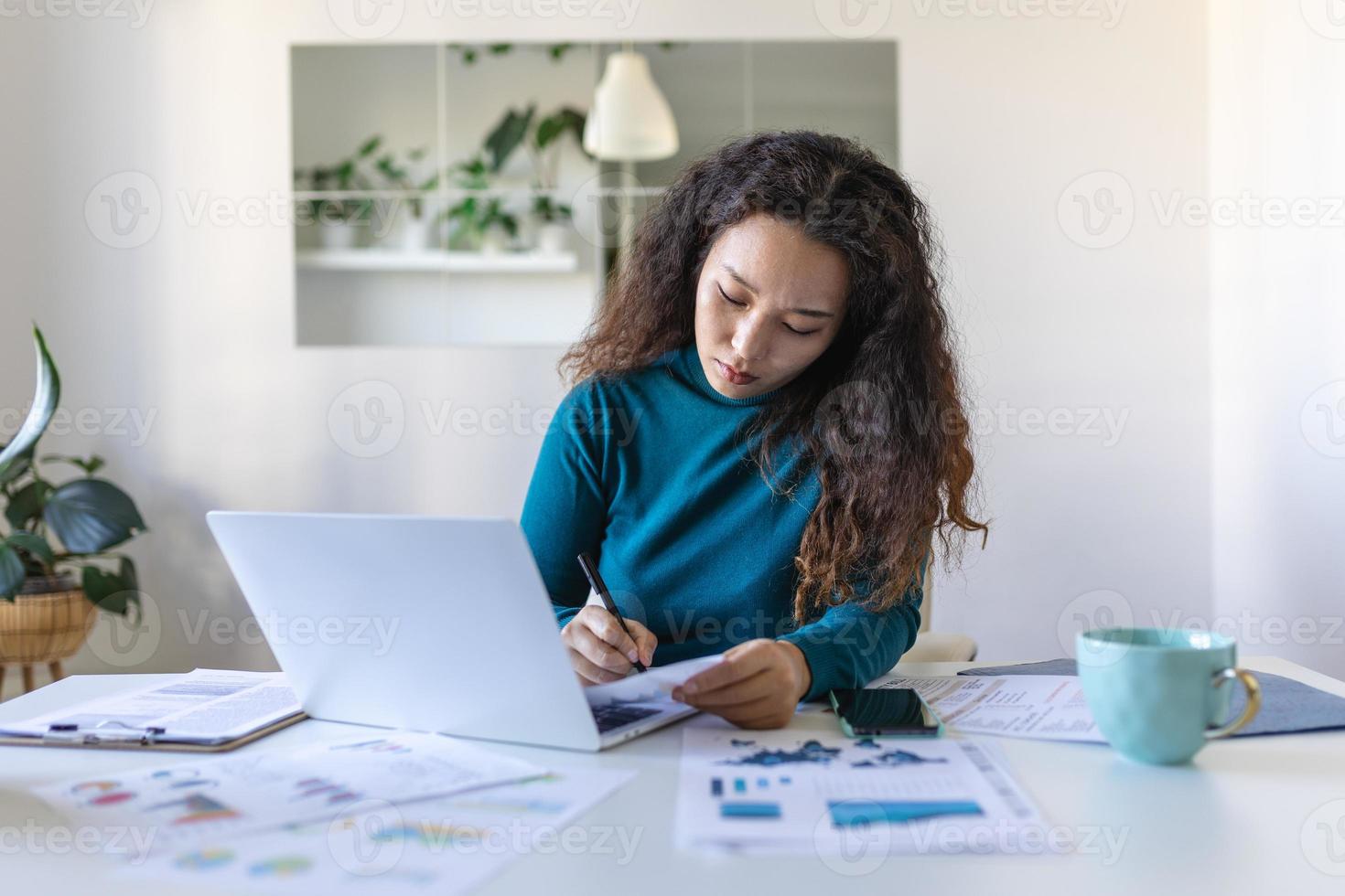 gefocust Aziatisch vrouw gebruik makend van laptop Bij huis, op zoek Bij scherm, chatten, lezing of schrijven e-mail, zittend Aan bank, vrouw leerling aan het doen huiswerk, werken Aan Onderzoek project online foto