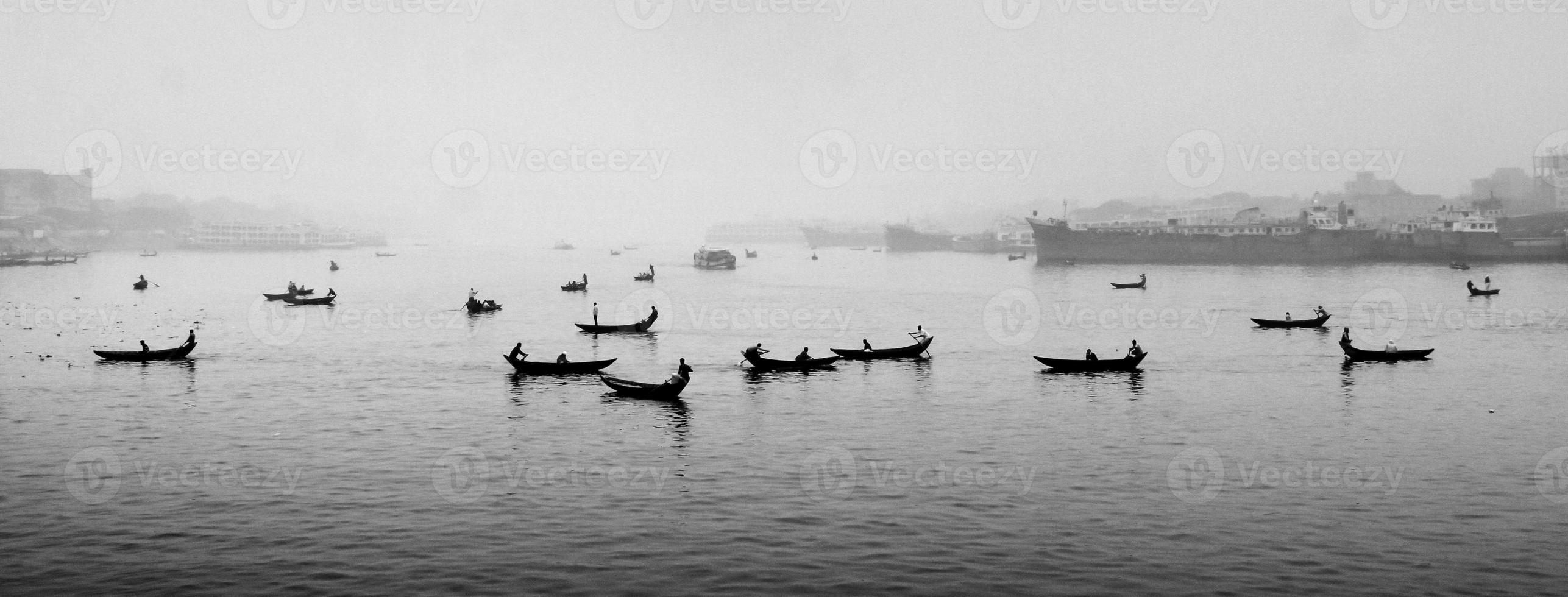 in de 's middags middag, mensen zijn kruispunt de rivier- door boot en deze jaar de mist van de winter is overspoeld in de rivier- buriganga. foto