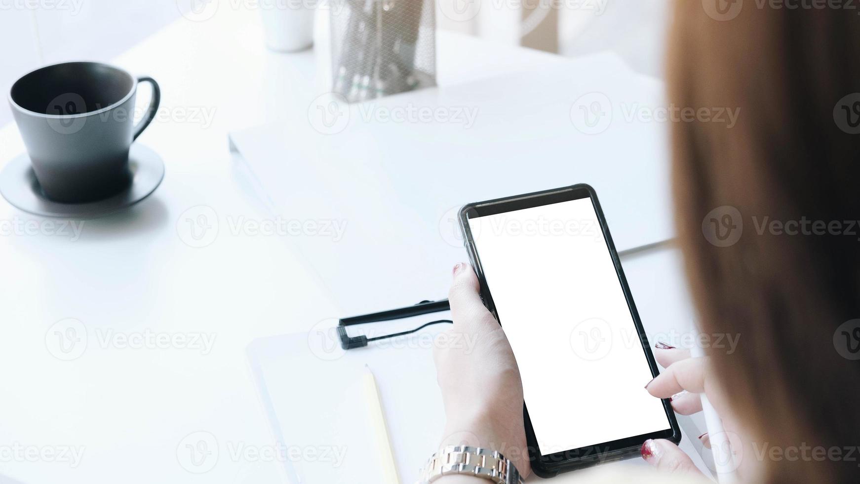 vrouw die telefoon met behulp van bij bureaumodel foto