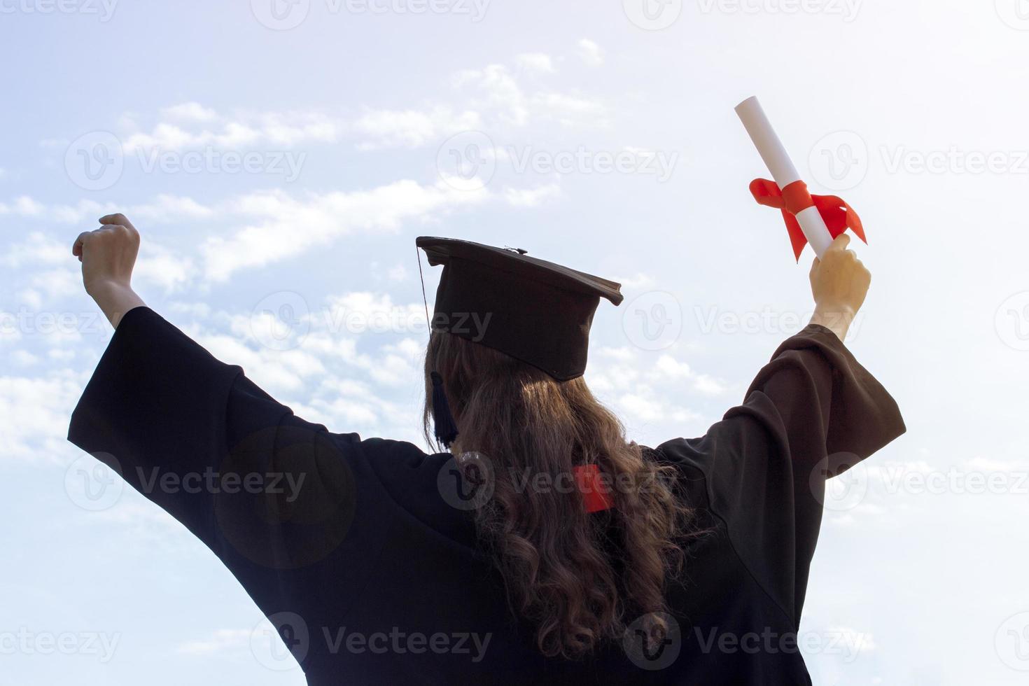 afstuderen zetten haar handen omhoog en vieren met certificaat in haar hand- en gevoel zo geluk in aanvang dag. afgezwakt foto