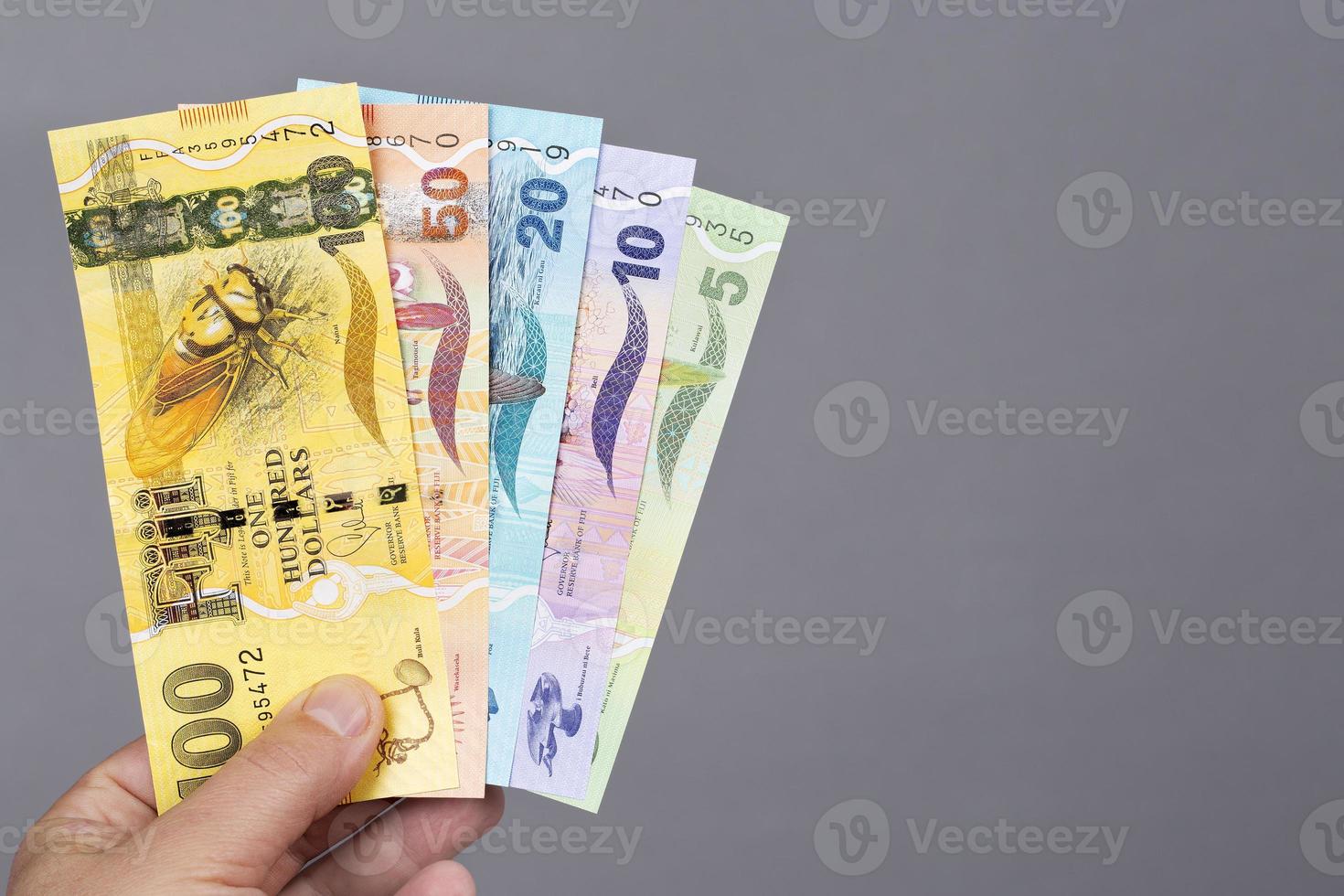 Fiji geld in de hand- Aan een grijs achtergrond foto