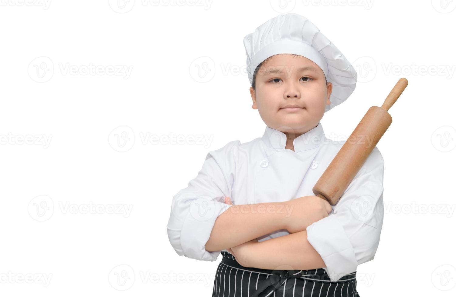 schattig jongen chef houden rollend pin met koken hoed foto