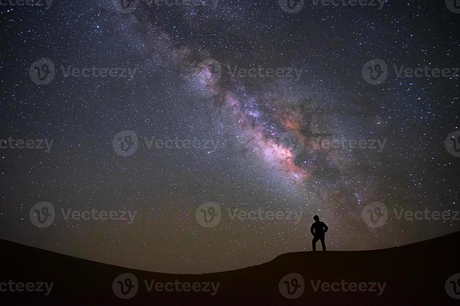 melkwegstelsel met een man die staat en kijkt naar de teerwoestijn, jaisalmer, india foto