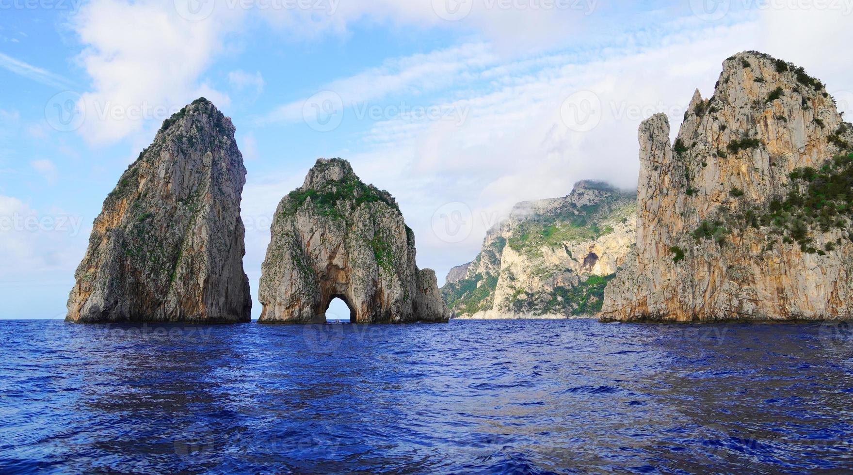 faraglioni rotsen in de buurt de eiland van driekwartsbroek, Italië foto