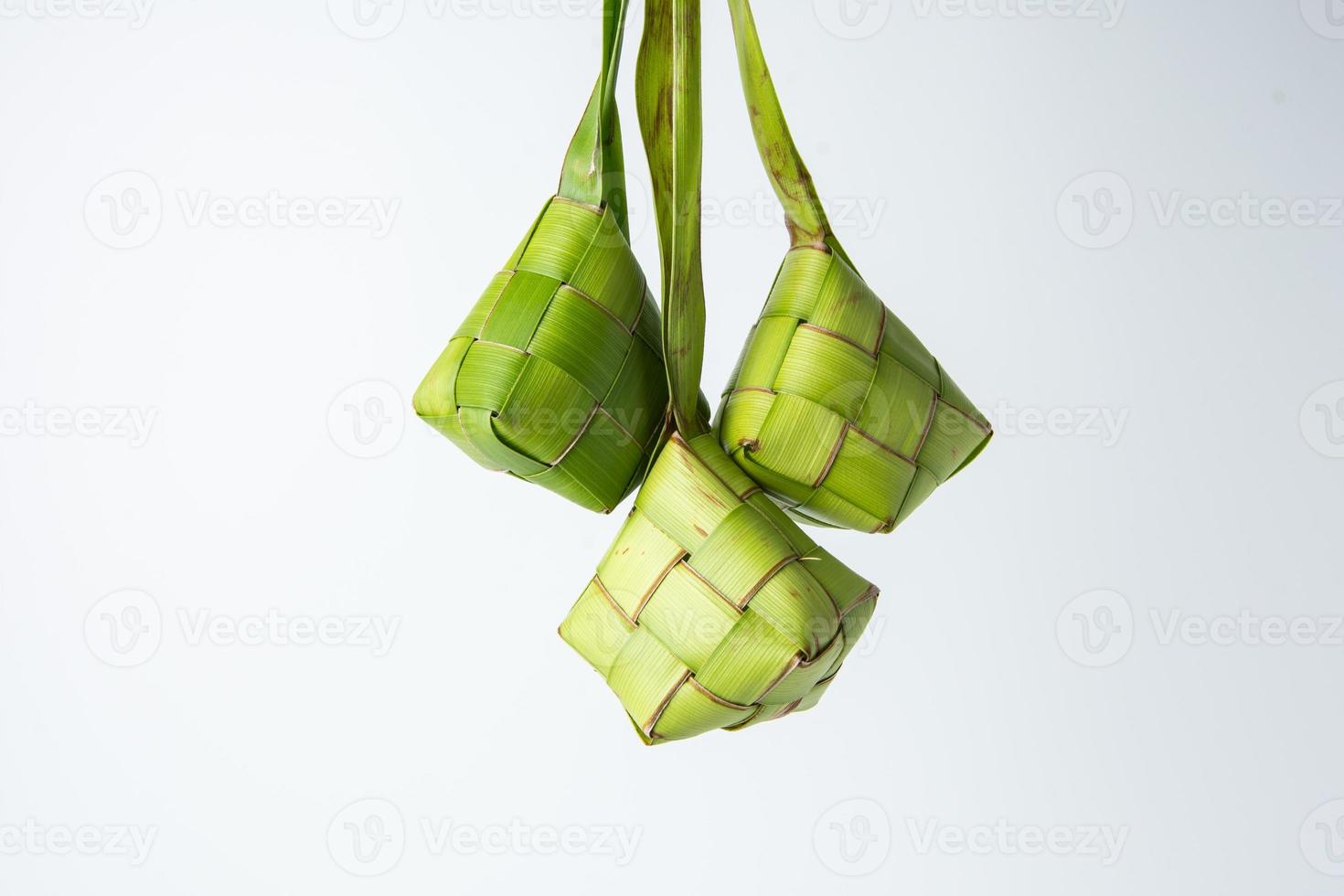 ketupat Lebaran is een typisch Indonesisch voedsel gedurende de feestelijk seizoen van ketupat, eid al fitr, eid al adha, natuurlijk rijst- inpakken gemaakt van jong kokosnoot bladeren Aan een wit achtergrond, leeg ruimte foto