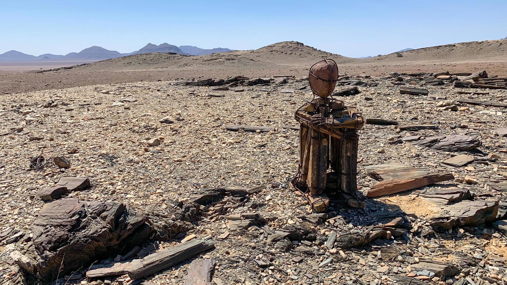kaokoveld, kunden, Namibië, 2021 - zittend eenzaam Mens in de enorm woestijn foto