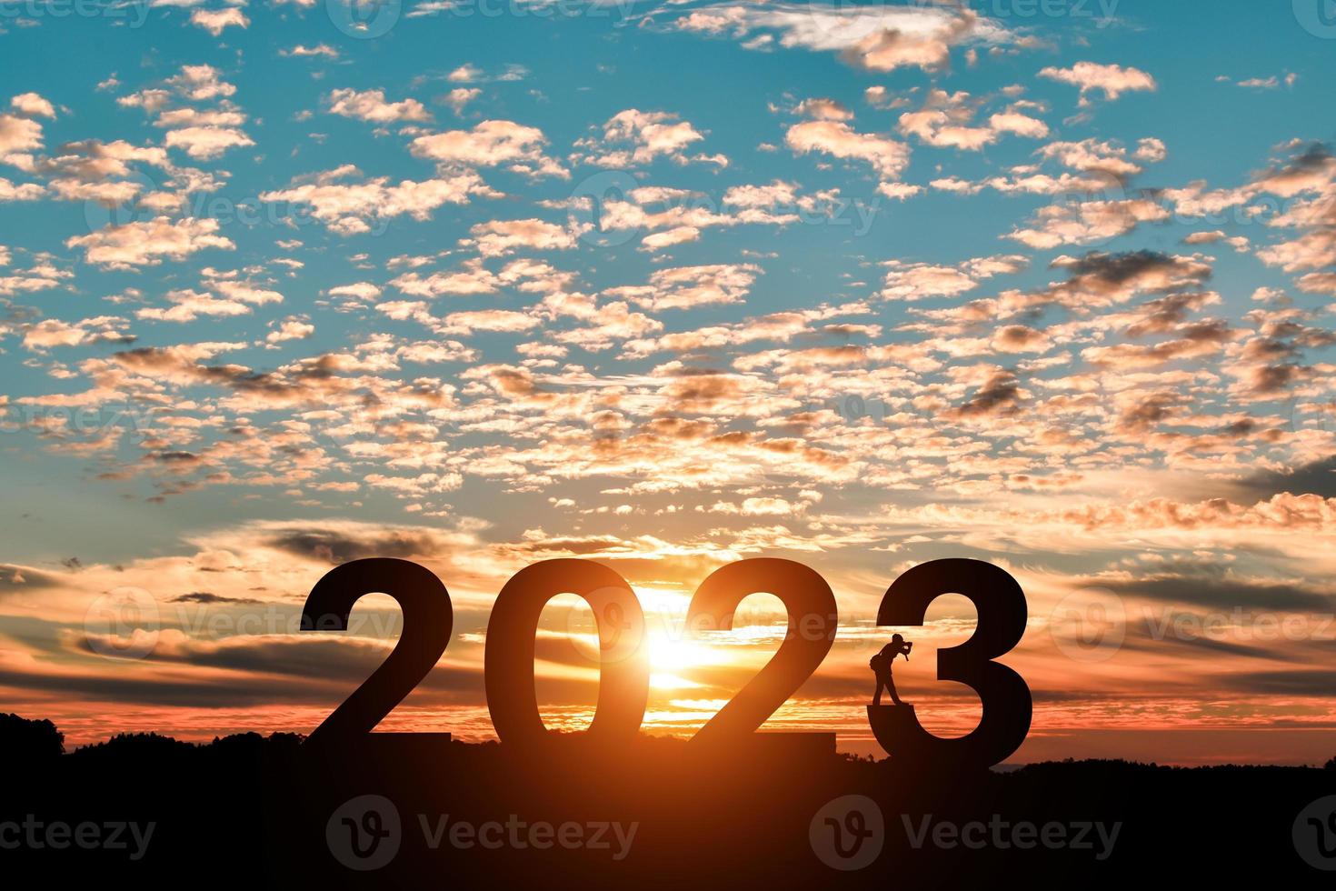 silhouet van fotograaf nemen foto's in 2023 jaren Bij zonsopkomst of zonsondergang achtergrond. idee voor gelukkig nieuw jaar 2022. foto