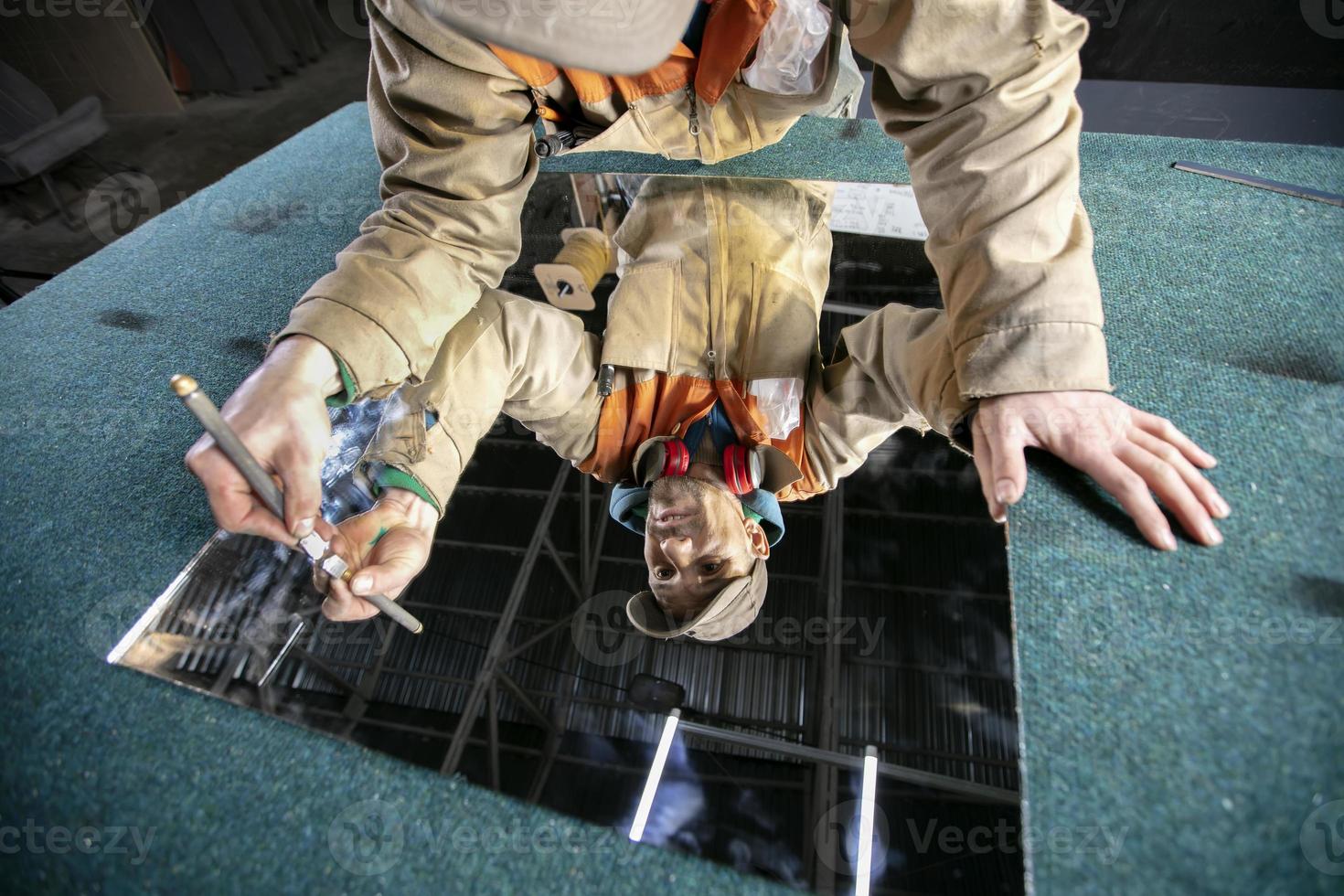 een arbeider bezuinigingen glas met een glas snijder. meubilair productie. foto