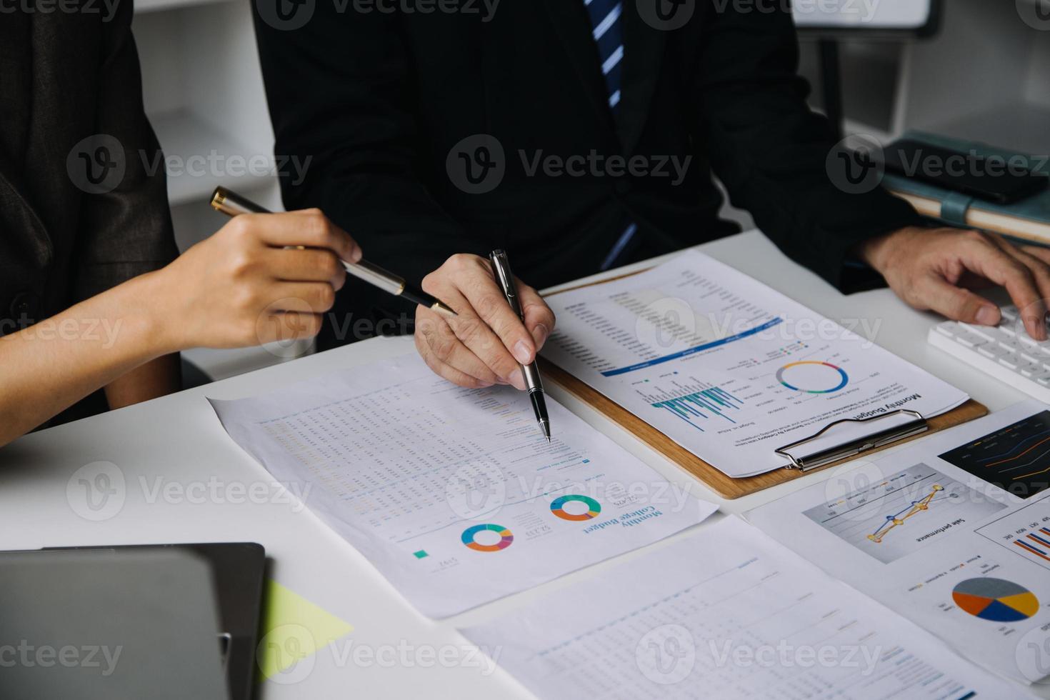 financiële analisten analyseren zakelijke financiële rapporten over een investeringsproject voor digitale tabletplanning tijdens een discussie op een bijeenkomst van bedrijven die de resultaten van hun succesvolle teamwerk laten zien. foto