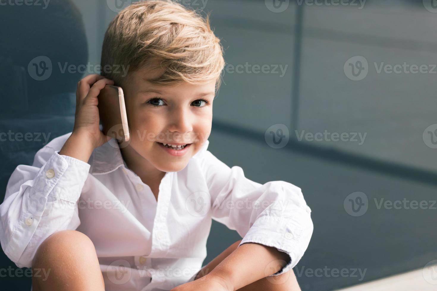 schattige jongen praten aan de telefoon foto