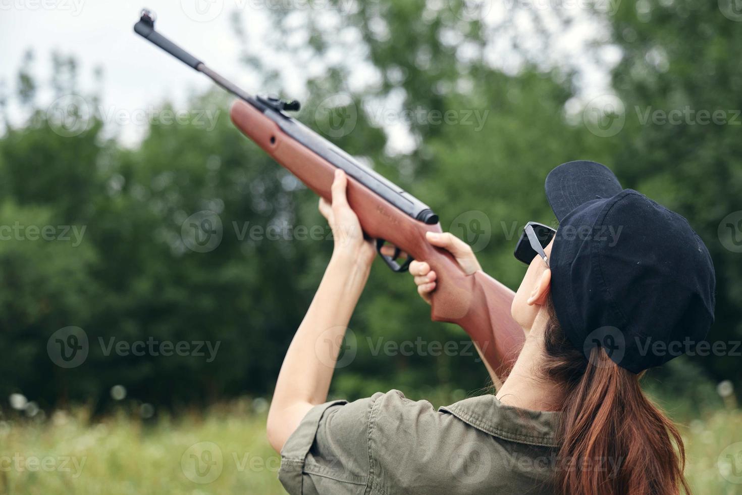 vrouw Aan natuur doel omhoog geweer jacht- terug visie zwart pet vers lucht groen foto