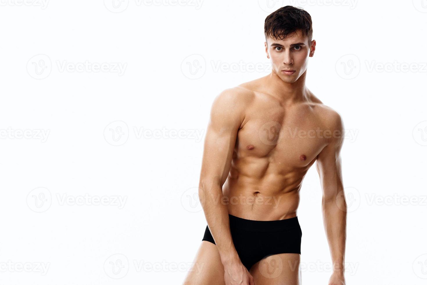 sexy bodybuilder met gemotiveerd omhoog torso en in zwart slipje bijgesneden visie geïsoleerd achtergrond foto