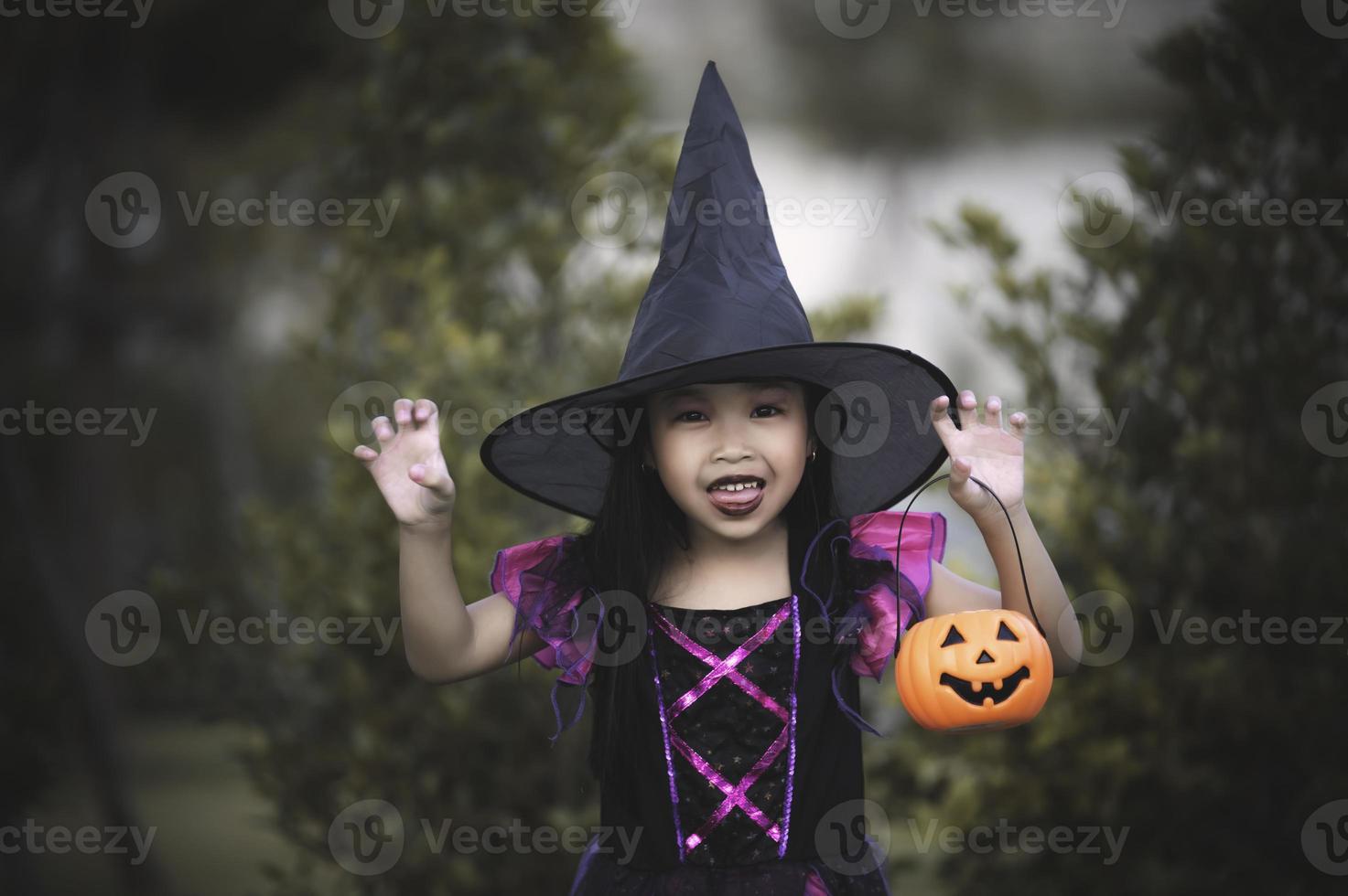 Aziatisch schattig vrouw kind slijtage heks kostuum met pompoen, halloween festival concept foto