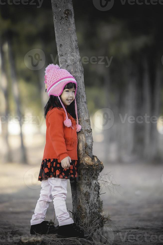 portret van schattig Aziatisch weinig meisje slijtage winter kleren Bij de Woud van de park, thailand mensen houding voor nemen een foto, gelukkig tijd foto